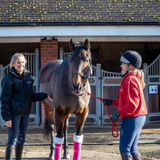 Two students with a horse in the Equine Yard