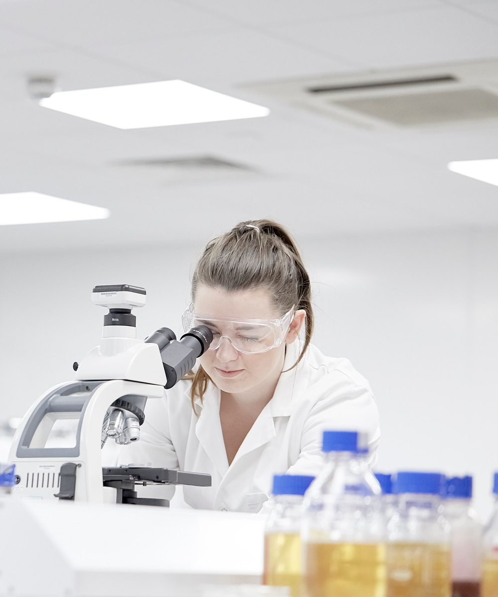 Female Student In Lab Using Microscope